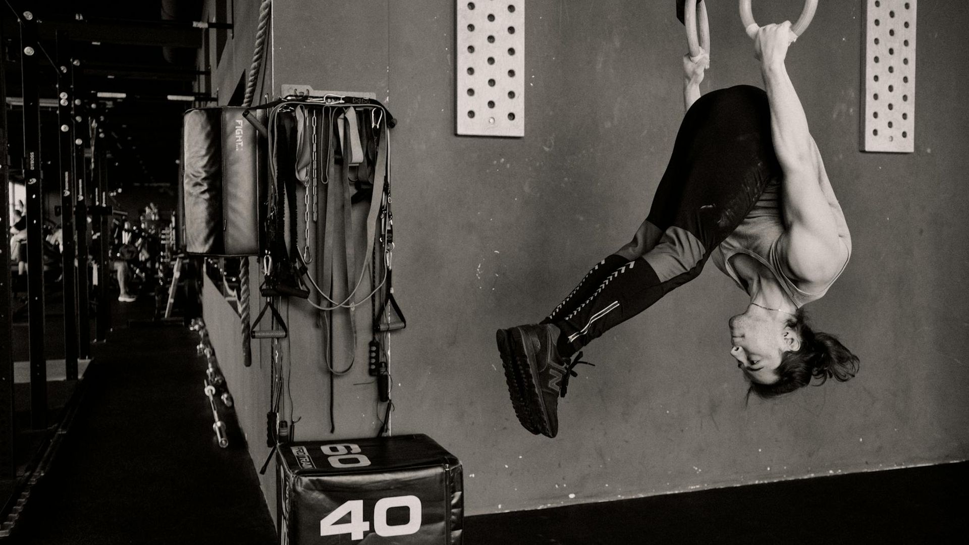 Athletic man performing strength exercises in a dark gym environment